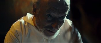 Movie still from “Empire of the Wolves” (2005), directed by Chris Nahon – An old man with a white beard looking at the camera; Close Up shot, Low angle