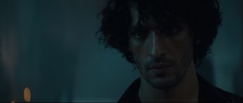 Movie still from “Empire of the Wolves” (2005), directed by Chris Nahon – A person's face in the dark; Close Up shot, Over the shoulder angle