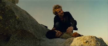 Movie still from “Empire of the Wolves” (2005), directed by Chris Nahon – A man helping another man who is laying on the ground; Medium shot, Low angle