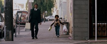 Movie still from “The Pursuit of Happyness” (2006), created by Frank Darabont – A man and a boy walking down the sidewalk; Wide shot, Low angle