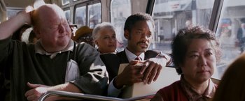 Movie still from “The Pursuit of Happyness” (2006), created by Frank Darabont – An older man and a younger woman riding a bus; Close Up shot, Low angle