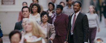 Movie still from “The Pursuit of Happyness” (2006), created by Frank Darabont – A group of people standing in a crowd of people; Medium shot, Over the shoulder angle