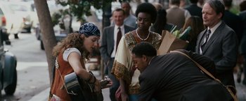 Movie still from “The Pursuit of Happyness” (2006), created by Frank Darabont – A group of people standing on a sidewalk; Medium shot, Over the shoulder angle