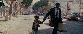 Movie still from “The Pursuit of Happyness” (2006), created by Frank Darabont – A man and a child walking down a street; Medium shot, Over the shoulder angle