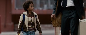 Movie still from “The Pursuit of Happyness” (2006), created by Frank Darabont – A young boy and a woman are walking down the street; Close Up shot, Over the shoulder angle