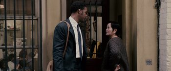 Movie still from “The Pursuit of Happyness” (2006), created by Frank Darabont – A man and a woman standing next to each other; Medium shot, Over the shoulder angle
