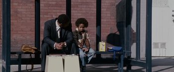 Movie still from “The Pursuit of Happyness” (2006), created by Frank Darabont – A man and a child sitting on a bench; Medium shot, Over the shoulder angle