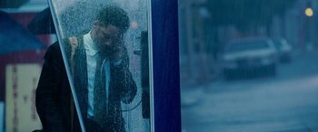 Movie still from “The Pursuit of Happyness” (2006), created by Frank Darabont – A man is talking on the phone in the rain; Medium shot, High angle