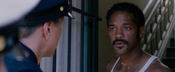 Movie still from “The Pursuit of Happyness” (2006), created by Frank Darabont – A man looking into a mirror while another man looks on; Close Up shot, Over the shoulder angle