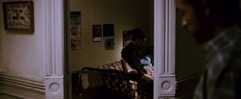 Movie still from “The Pursuit of Happyness” (2006), created by Frank Darabont – A woman sitting on top of a bed next to a man; Medium shot, Low angle