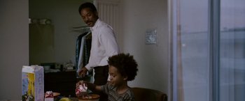 Movie still from “The Pursuit of Happyness” (2006), created by Frank Darabont – A man and a boy sitting at a dining table; Medium shot, Over the shoulder angle