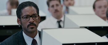 Movie still from “The Pursuit of Happyness” (2006), created by Frank Darabont – A group of people in a room with computers; Close Up shot, Over the shoulder angle