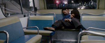 Movie still from “The Pursuit of Happyness” (2006), created by Frank Darabont – A man and a boy are sitting on a train; Medium shot, High angle