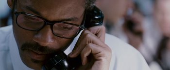 Movie still from “The Pursuit of Happyness” (2006), created by Frank Darabont – A person talking on a phone; Close Up shot, Overhead angle