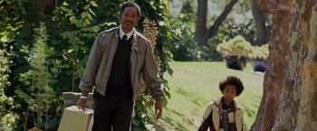 Movie still from “The Pursuit of Happyness” (2006), created by Frank Darabont – A man standing next to a woman in a field; Medium shot, Over the shoulder angle