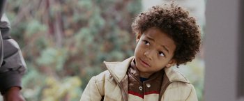 Movie still from “The Pursuit of Happyness” (2006), created by Frank Darabont – A little boy in a brown and white jacket looking up; Close Up shot, High angle