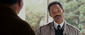 Movie still from “The Pursuit of Happyness” (2006), created by Frank Darabont – A person wearing a suit and a tie; Close Up shot, Over the shoulder angle