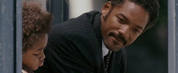 Movie still from “The Pursuit of Happyness” (2006), created by Frank Darabont – A person wearing a suit and tie; Close Up shot, Over the shoulder angle