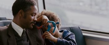 Movie still from “The Pursuit of Happyness” (2006), created by Frank Darabont – A man and a child are playing with a pair of toy scissors; Close Up shot, Over the shoulder angle