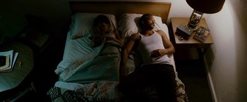 Movie still from “The Pursuit of Happyness” (2006), created by Frank Darabont – A man and a woman laying in a bed together; Medium shot, Overhead angle