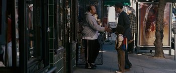 Movie still from “The Pursuit of Happyness” (2006), created by Frank Darabont – Two men standing on a sidewalk talking to a child; Wide shot, Over the shoulder angle