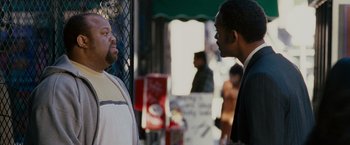 Movie still from “The Pursuit of Happyness” (2006), created by Frank Darabont – Two men standing next to each other on the sidewalk; Medium shot, Over the shoulder angle