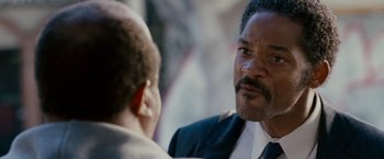 Movie still from “The Pursuit of Happyness” (2006), created by Frank Darabont – A man wearing a suit and tie talking to another man wearing a suit and tie; Close Up shot, Over the shoulder angle