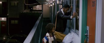 Movie still from “The Pursuit of Happyness” (2006), created by Frank Darabont – A man and a child in a hallway looking out a window; Medium shot, Over the shoulder angle