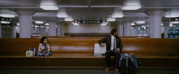 Movie still from “The Pursuit of Happyness” (2006), created by Frank Darabont – A man sitting on top of a bench next to luggage; Wide shot, High angle