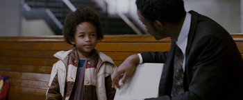 Movie still from “The Pursuit of Happyness” (2006), created by Frank Darabont – A man pointing at a young boy sitting on a wooden bench; Close Up shot, Over the shoulder angle