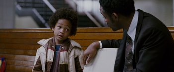 Movie still from “The Pursuit of Happyness” (2006), created by Frank Darabont – A man pointing to a laptop computer next to a young boy; Close Up shot, Over the shoulder angle
