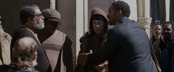 Movie still from “The Pursuit of Happyness” (2006), created by Frank Darabont – A group of men standing next to each other on a sidewalk; Medium shot, Over the shoulder angle