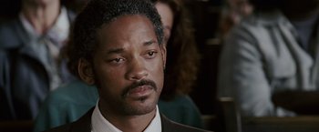 Movie still from “The Pursuit of Happyness” (2006), created by Frank Darabont – A person wearing a suit and tie; Close Up shot, Over the shoulder angle