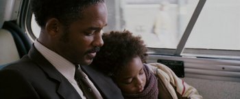 Movie still from “The Pursuit of Happyness” (2006), created by Frank Darabont – A man and a child sitting next to each other on a bus; Close Up shot, Over the shoulder angle