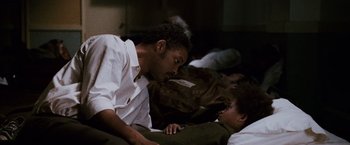 Movie still from “The Pursuit of Happyness” (2006), created by Frank Darabont – Two men lying on the ground and one is looking at the other; Close Up shot, Over the shoulder angle
