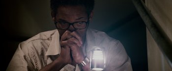 Movie still from “The Pursuit of Happyness” (2006), created by Frank Darabont – A man holding a light in front of his face; Close Up shot, High angle