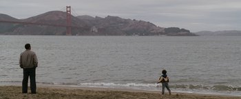 Movie still from “The Pursuit of Happyness” (2006), created by Frank Darabont – A woman walking on the beach near the water; Extreme Wide shot, Over the shoulder angle