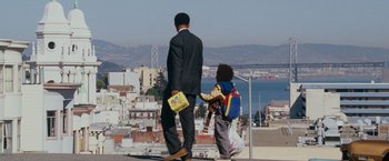 Movie still from “The Pursuit of Happyness” (2006), created by Frank Darabont – A man and a child standing on the side of a road; Wide shot, Low angle