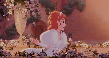 Movie still from “Enchanted” (2007), directed by Kevin Lima – A woman in a white dress is sitting in a flower garden; Wide shot, Overhead angle