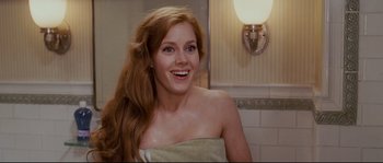 Movie still from “Enchanted” (2007), directed by Kevin Lima – A woman with a towel around her neck smiles for the camera in a bathroom; Close Up shot, Over the shoulder angle