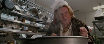 Movie still from “Enchanted” (2007), directed by Kevin Lima – A man in a chef's hat stirring a pot in a commercial kitchen; Close Up shot, Low angle