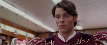 Movie still from “Enchanted” (2007), directed by Kevin Lima – A man wearing a purple and gold uniform; Close Up shot, Over the shoulder angle