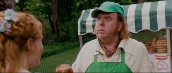 Movie still from “Enchanted” (2007), directed by Kevin Lima – A man in a green hat and apron looks at the camera; Close Up shot, Over the shoulder angle