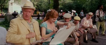 Movie still from “Enchanted” (2007), directed by Kevin Lima – A woman in a blue dress is signing a book; Medium shot, Over the shoulder angle