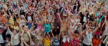 Movie still from “Enchanted” (2007), directed by Kevin Lima – A large group of people with their hands up; Wide shot, High angle