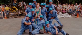 Movie still from “Enchanted” (2007), directed by Kevin Lima – A group of men and women wearing blue hard hats; Wide shot, Low angle