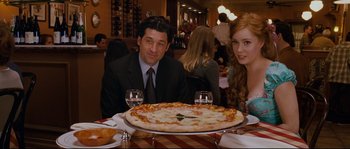 Movie still from “Enchanted” (2007), directed by Kevin Lima – A man and a woman sitting in front of a pizza; Medium shot, Over the shoulder angle