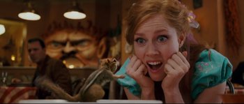 Movie still from “Enchanted” (2007), directed by Kevin Lima – A woman holding a phone up to her face with a squirrel sitting on her shoulder; Close Up shot, Over the shoulder angle