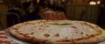Movie still from “Enchanted” (2007), directed by Kevin Lima – A pizza sitting on top of a table; Extreme Close Up shot, Overhead angle