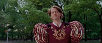 Movie still from “Enchanted” (2007), directed by Kevin Lima – A young man in a costume poses for a picture; Medium shot, Over the shoulder angle